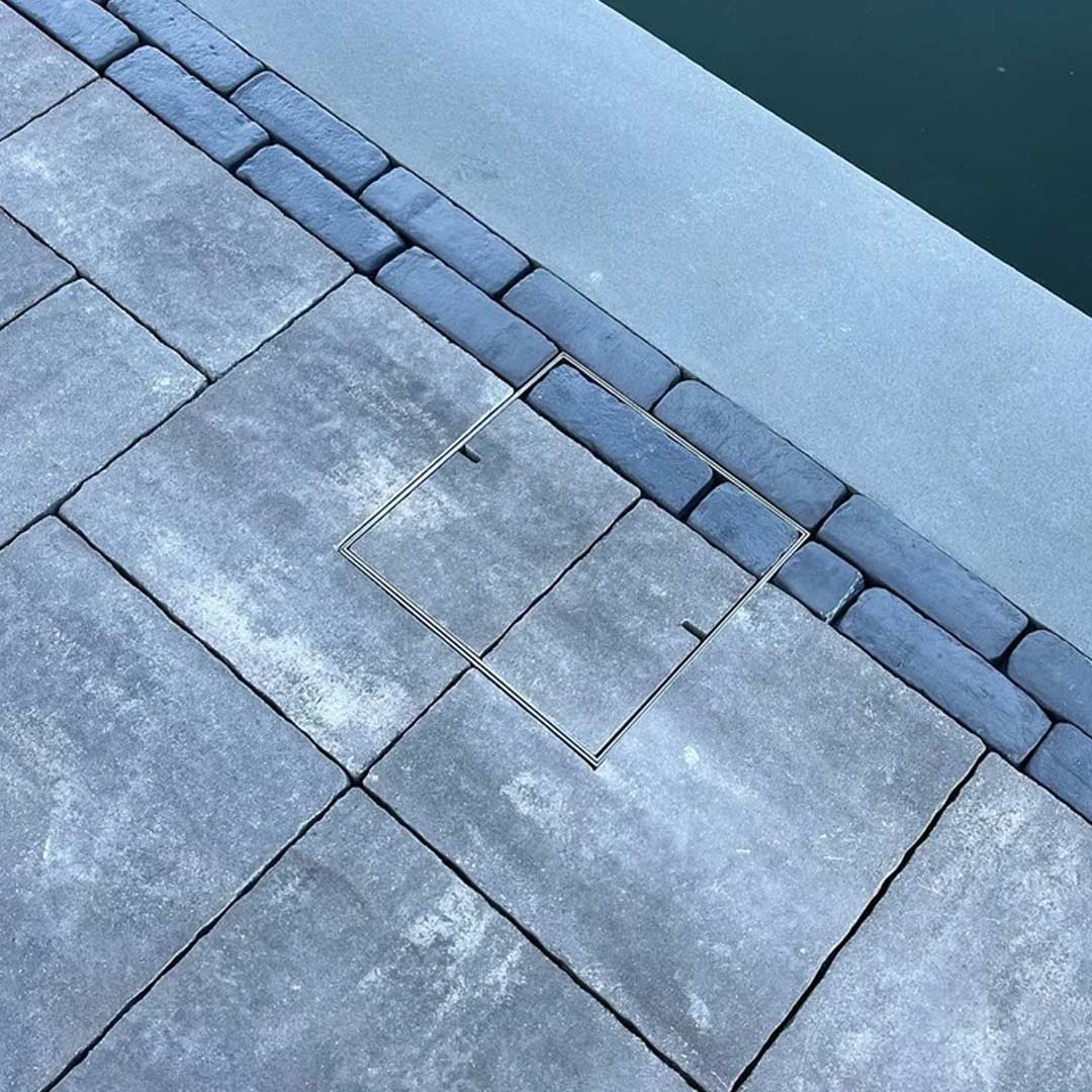 Hidden Skimmer Covers with paving pattern inlay sitting flush beside swimming pool