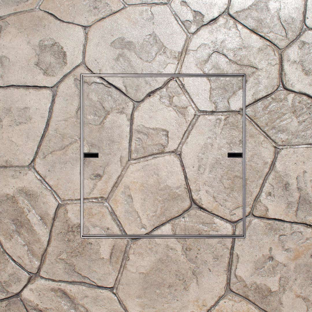 HIDE stainless steel Access Cover installed flush in decorative stamped concrete, with joint lines continuing through the cover to match the surrounding pattern.