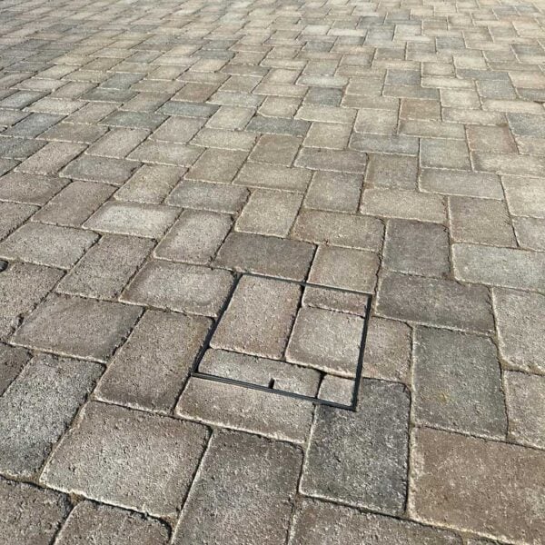 Stainless Steel Access Cover with brown paving inlay following surrounding paving pattern.