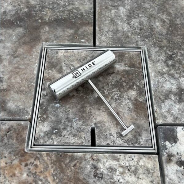 Small 156mm HIDE Access Cover with brown stone inlay and HIDE safety key sitting on top.