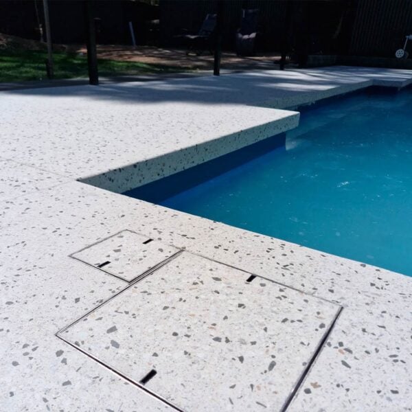 HIDE Access Cover and Skimmer Cover next to each other with honed exposed aggregate concrete finish.