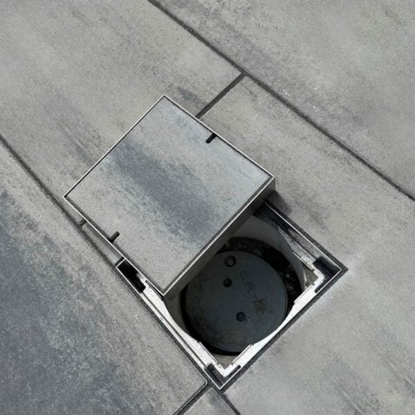 HIDE stainless steel Access Cover opened in paving, showing the recessed inlay lid and the service access point below.
