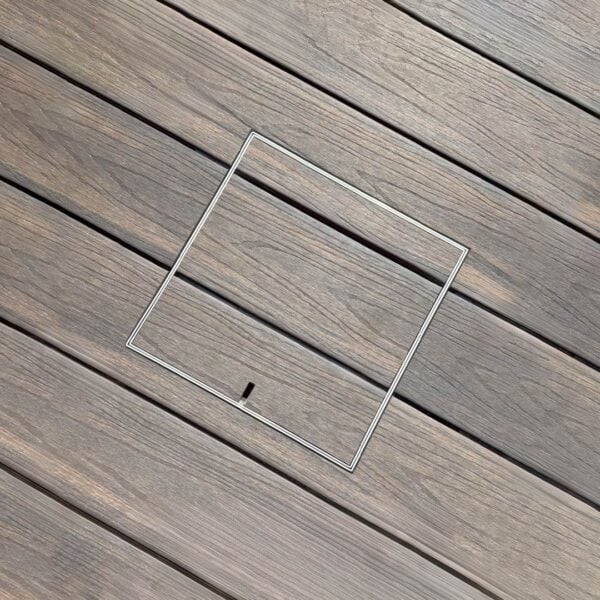 HIDE stainless steel skimmer cover set flush in timber decking; board joints align through the cover for a concealed finish.