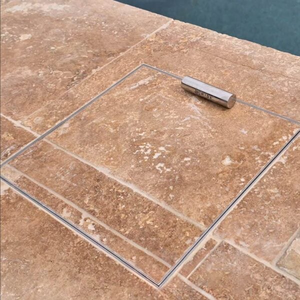 Close up of HIDE Skimmer Cover with orange tile inlay, tile and grout pattern running through the Cover.