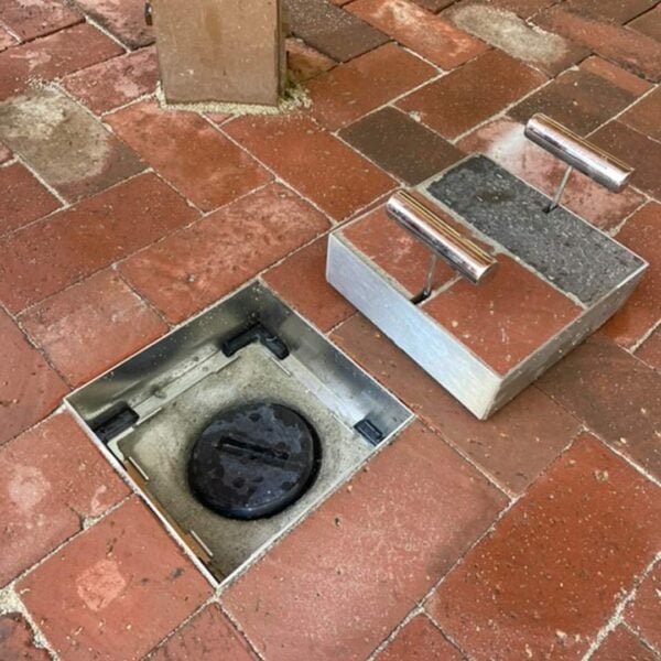 Stainless Steel small HIDE Access Cover with HIDE Lid lifted to see black service access point with black plug underneath.