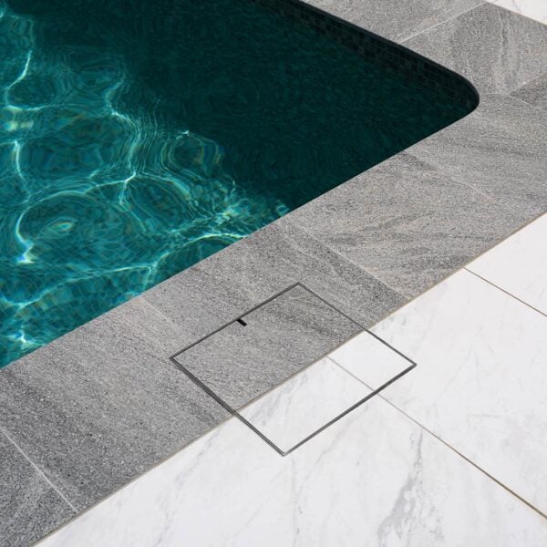 HIDE Skimmer Cover with dual grey and white tile inlay next to architectural curved round pool..