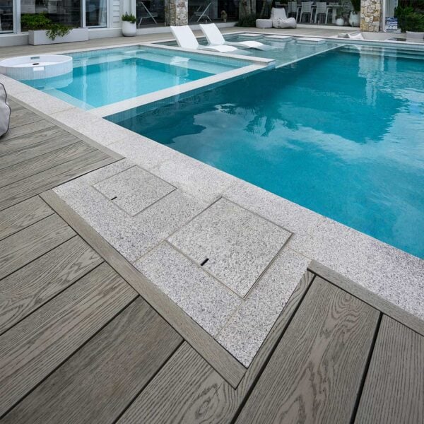 HIDE Access Cover and Skimmer Cover next to modern pool with grey tile inlay.