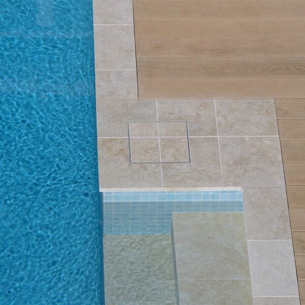 HIDE Skimmer Cover with cream tile pattern running through the middle next to pool.
