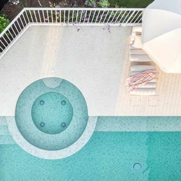 Two HIDE Concrete Skimmer Lids with white concrete aggregate infill next to concrete pool.