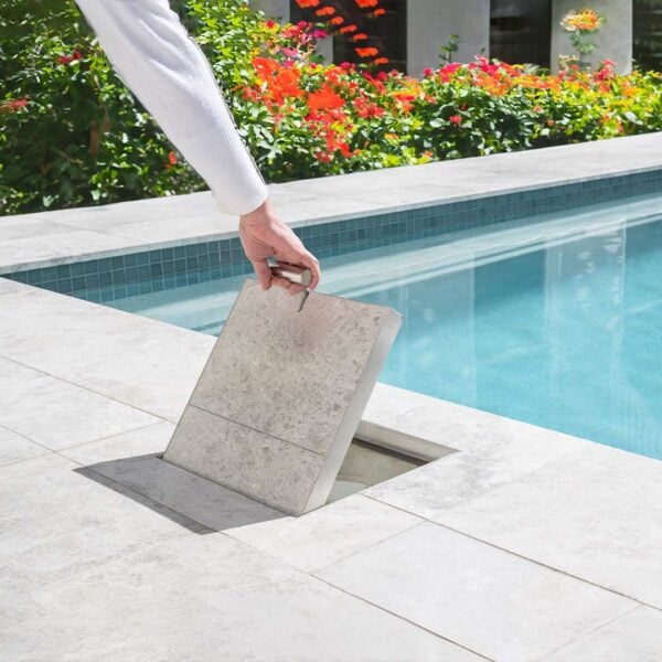 HIDE Skimmer Cover being lifted next to pool to show skimmer box opening underneath.