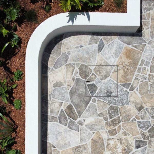 HIDE Manhole Cover with crazy pave inlay next to garden.