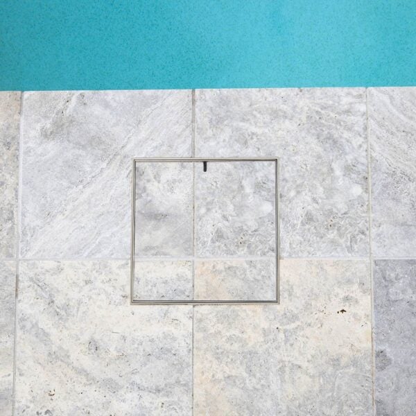 HIDE Skimmer Cover with grey tile pattern next to pool.